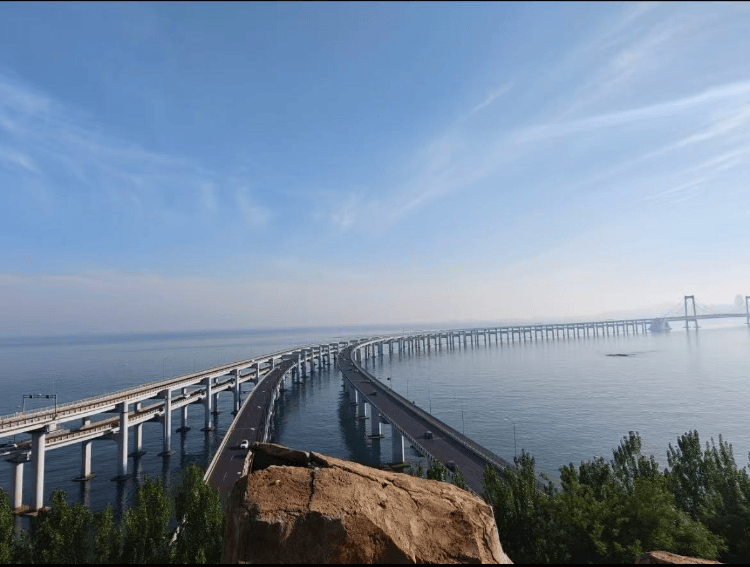 大连一跨海大桥观景台有游客翻栏杆踩空心造景石拍照,当地回应